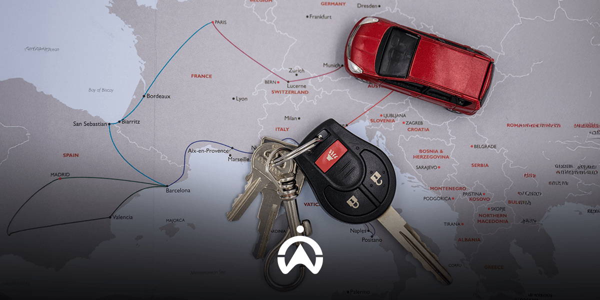 A red toy car and a set of keys placed on a map of Europe, highlighting travel routes in France, Spain, and beyond.